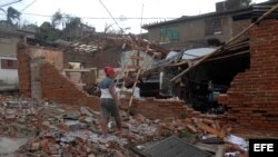  Una mujer observa los destrozos ocasionados a su hogar por el paso del huracán "Sandy" en la ciudad de Santiago de Cuba.