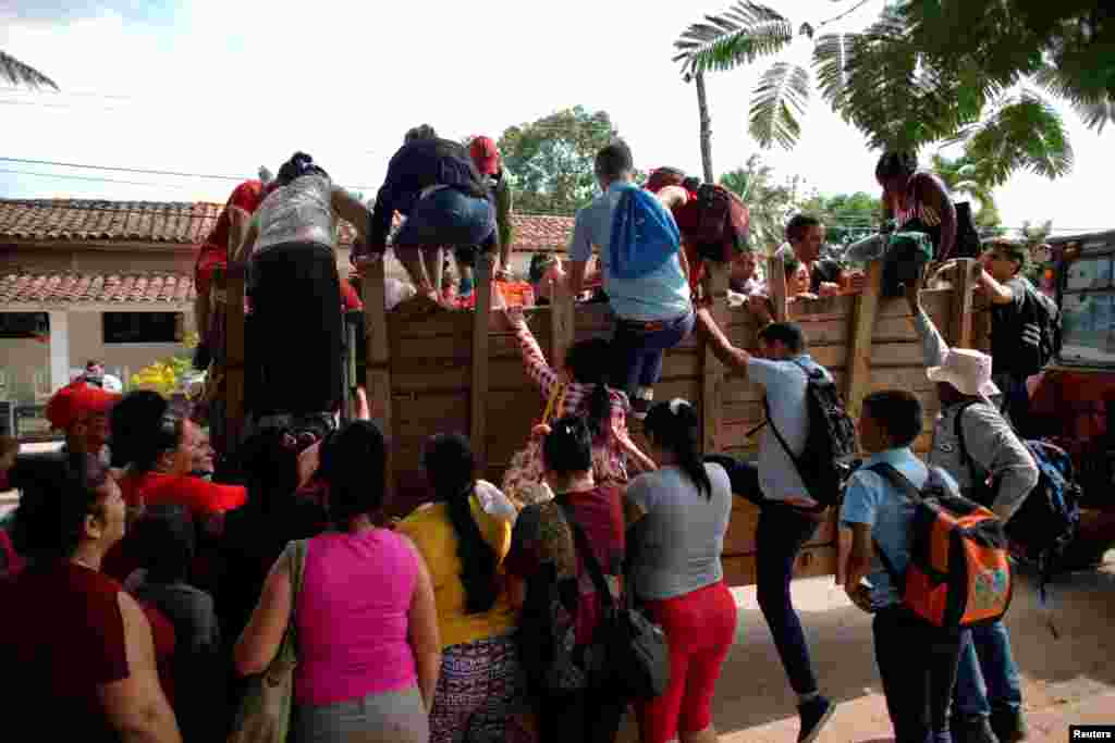 Pasajeros se suben al vagón de un tractor, en Viñales, Pinar del Río. (REUTERS/Alexandre Meneghini)