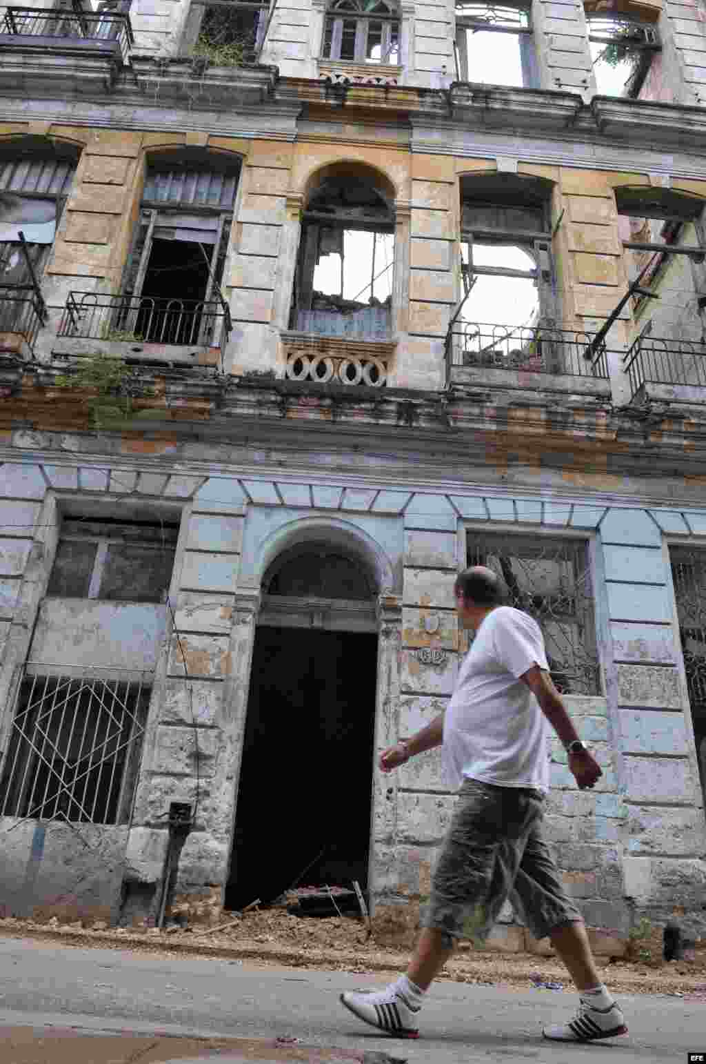 Un hombre camina frente a un edificio que se derrumbó parcialmente en Centro Habana