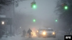Peatones y vehículos circulan por las calles nevadas del distrito de Brooklyn en Nueva York (Estados Unidos).
