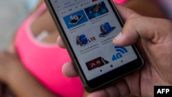 Un joven cubano se conecta a internet desde su teléfono. (YAMIL LAGE / AFP)