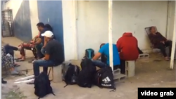 Cubanos detenidos en Costa Rica, de un grupo de 29, esperan en el patio de una unidad policial.