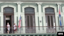 Dos empleadas acomodan una bandera estadounidense en el hotel donde llegó una comitiva de senadores de EE.UU. 