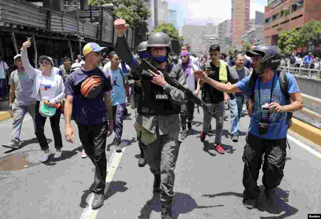 Un miembro de la Guardia Nacional Bolivariana se une a los manifestantes de la oposición durante las protestas en Caracas.
