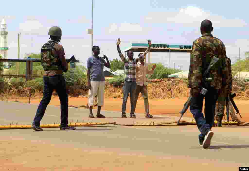 Oficiales de seguridad interrogan a civiles en la carretera donde los médicos fueron secuestrados. en Mandera Kenia.