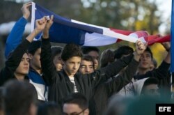Un grupo de jóvenes sostiene una bandera de Francia en solidaridad con ese país en el Washington Square Park en Nueva York.