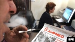 Un hombre fuma en una oficina. 
