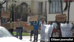 Imagen de los doce activistas protestando frente a la sede de la Asamblea Nacional del Poder Popular en el municipio Playa, Ciudad Habana.