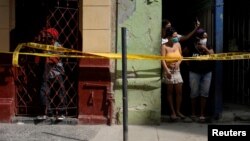 Personas en cuarentena en sus hogares por el COVID-19, en una calle de La Habana. REUTERS/Alexandre Meneghini
