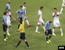 El árbitro alemán Félix Brych (c) saca la tarjeta roja al defensa uruguayo Maximiliano Pereira (d), tras cometer falta al delantero costarricense Joel Campbell.