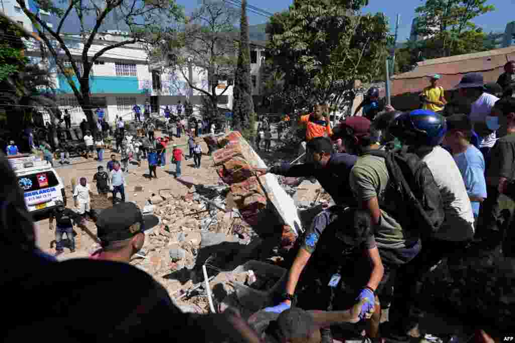 Rescatistas y residentes buscan sobrevivientes entre los escombros de un edificio colapsado por el sismo en Cali, Colombia. 