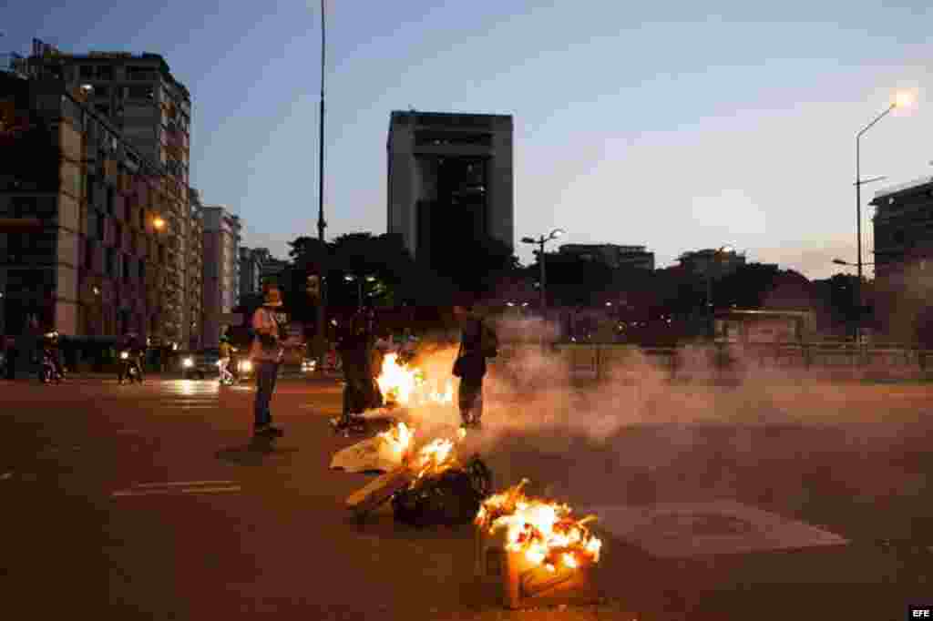 Un grupo de manifestantes quema basura en la plaza Altamira de Caracas. Al menos dos muertos, 23 heridos y más de 25 detenidos es el saldo que de momento arroja la jornada de protestas que se registró hoy en Venezuela, según fuentes oficiales.