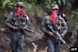 Guerrileros del Ejército de Liberación Nacional (ELN) patrullan el río Baudó en la provincia de Chocó, Colombia, el 26 de octubre de 2023.