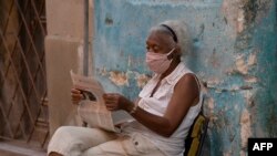 Una señora lee el periódico Granma en La Habana (Yamil Lage/AFP).