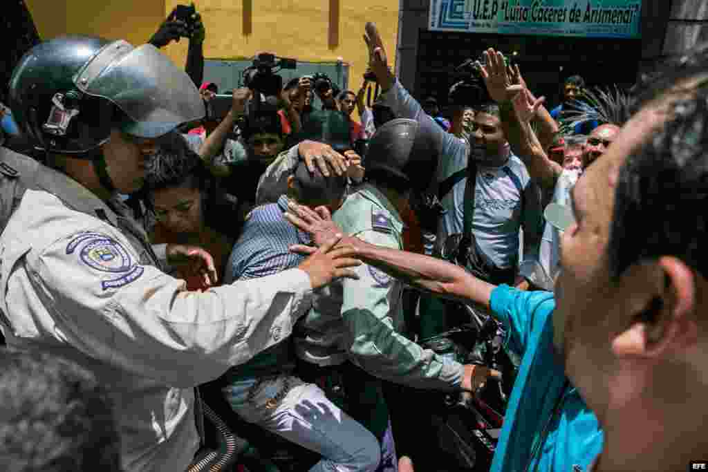 Un cordón policial separa al grupo de seguidores del opositor venezolano Leopoldo López, y otro grupo oficialista.