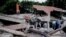 Un rescatista levanta los puños para pedir silencio mientras se localiza a las víctimas bajo los escombros de un edificio derrumbado tras el simo, Cali, Colombia.