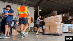 Voluntarios organizan donativos en almacén de la ong GEM, en Doral. (OCB)