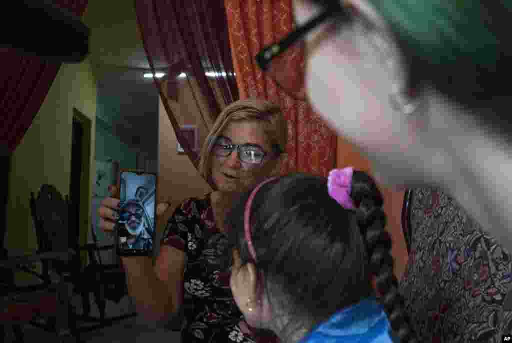 Danmara Triana sostiene su celular durante una videollamada con su esposo Roberto de la Iglesia, quien vive en Estados Unidos desde 2015 con su hijo. &nbsp;(AP Foto/Ramón Espinosa)