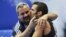 Danell Leyva besa a su entrenador y padrastro Yin Álvarez tras ganar el oro en la prueba de paralelas del campeonato Mundial de Gimnasia Artística el 16 de octubre de 2011, en Tokio, Japón.