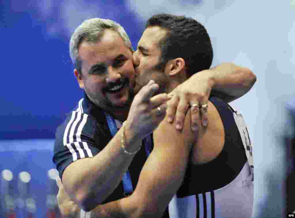 Danell Leyva besa a su entrenador y padrastro Yin Álvarez tras ganar el oro en la prueba de paralelas del campeonato Mundial de Gimnasia Artística el 16 de octubre de 2011, en Tokio, Japón.