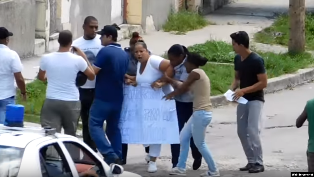 Una Dama de Blanco es detenida cuando sale a marchar con una pancarta alusiva a la ampaña Todos Marchamos el domingo 19 de septiembre,