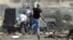 Palestinos lanzan piedras a un vehículo policial israelí durante un protesta contra el asentamiento judío de Kedumim, en Cisjordania.