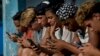 Jóvenes cubanos se conectan a internet desde su teléfono móvil en La Habana.