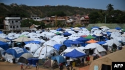 Personas desplazadas se refugian en tiendas de campaña en el estadio de béisbol César Nieves, en el barrio La Angustia de Catia La Mar, La Guaira, Venezuela, el 8 de julio de 2026. Raul ARBOLEDA / AFP