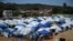 Personas desplazadas se refugian en tiendas de campaña en el estadio de béisbol César Nieves, en el barrio La Angustia de Catia La Mar, La Guaira, Venezuela, el 8 de julio de 2026. Raul ARBOLEDA / AFP