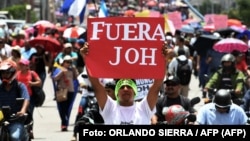 En la foto de archivo del 6 de agosto de 2019, cientos de personas participan en una protesta para exigir la renuncia del presidente hondureño, Juan Orlando Hernández, por sus presuntos vínculos con el narcotráfico, en Tegucigalpa. Foto: ORLANDO SIERRA / AFP