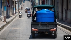 Un triciclo motorizado transporta un gran depósito de agua por un barrio de Matanzas, Cuba, el 6 de agosto de 2026.