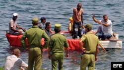 En esta foto de archivo, guardafronteras cubanos abordan una embarcación rústica en la Habana en un intento de frenar una salida ilegal.