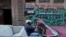 Un hombre pasa en su carro por una calle donde hay un cartel que invita a votar en las próximas elecciones legislativas del 26 de marzo. (REUTERS/Alexandre Meneghini).