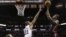  Dwyane Wade (d) se alza por encima del bloqueo de Tim Duncan (centro). Wade estuvo imparable, llevando 32 puntos al marcador.