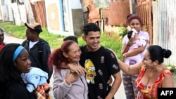 Marlon Brando Díaz (C-R), encarcelado por su participación en las protestas antigubernamentales de julio de 2021, saluda a sus familiares tras salir de prisión en el barrio Güinera de La Habana, el 16 de enero de 2025.