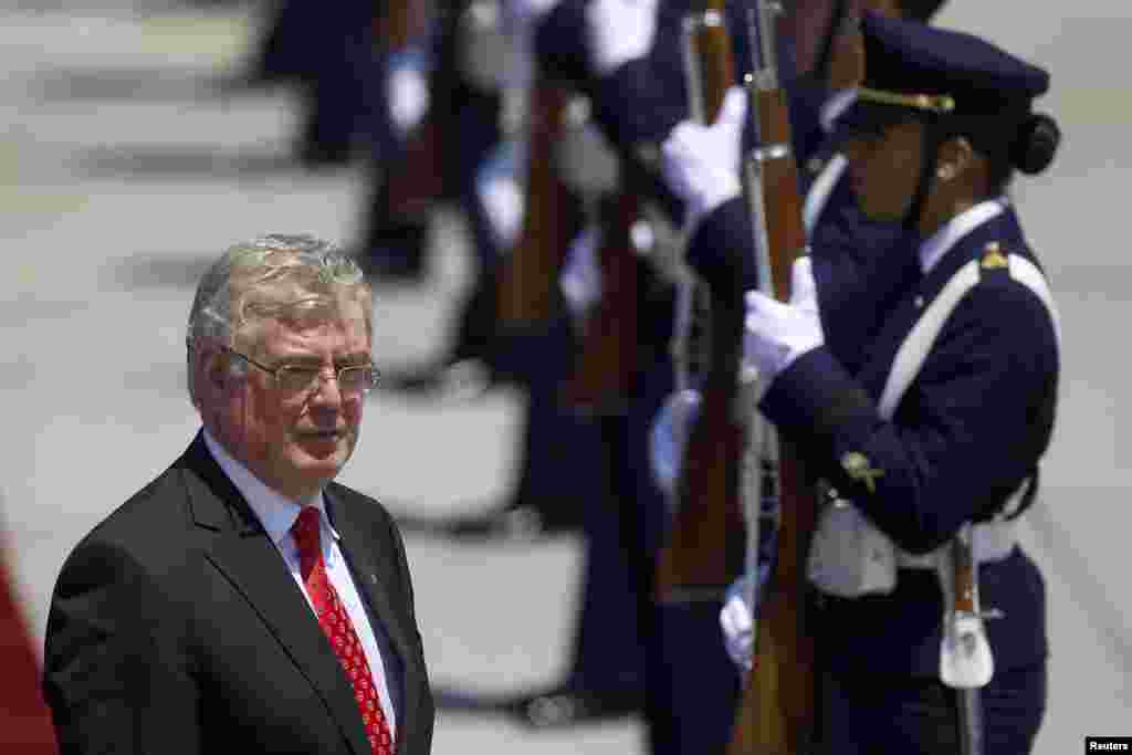Ministro de Exteriores irland&eacute;s Eamon Gilmore pasa junto a la guardia de honor a su llegada para asistir a la Cumbre de la CELAC-UE, en el aeropuerto de Santiago.
