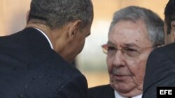 El presidente estadounidense, Barack Obama (i), saluda a Raúl Castro, durante el servicio religioso oficial del expresidente sudafricano Nelson Mandela en el estadio FNB de Soweto en Johannesburgo. 