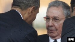 El presidente estadounidense, Barack Obama (i), saluda su homólogo cubano, Raúl Castro, durante el servicio religioso oficial del expresidente sudafricano Nelson Mandela en el estadio FNB de Soweto en Johannesburgo. 