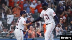 José Altuve felicita a Yordán Alvarez tras batear su primer cuadrangular de la temporada.