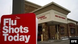 Vista general de una farmacia en la que han colocado un cartel en el que se puede leer "inyecciones contra la gripe hoy"