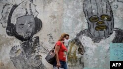 Una mujer usa una máscara protectora contra el coronavirus en una calle de La Habana. (YAMIL LAGE / AFP)
