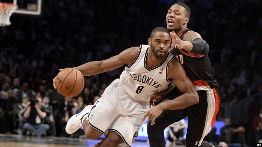 El jugador Deron Williams (C) de los Brooklyn Nets disputa el balón con Damian Lillard (d) de los Portland Trail Blazers durante el primer cuarto de su partido de la NBA en el Barclays Center en Brooklyn (Estados Unidos). 