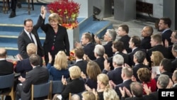 La canciller alemana, Angela Merkel (d), y el presidente francés, François Hollande (i), durante la ceremonia de entrega del Nobel de la Paz a la Unión Europea (UE) en Oslo, Noruega. 