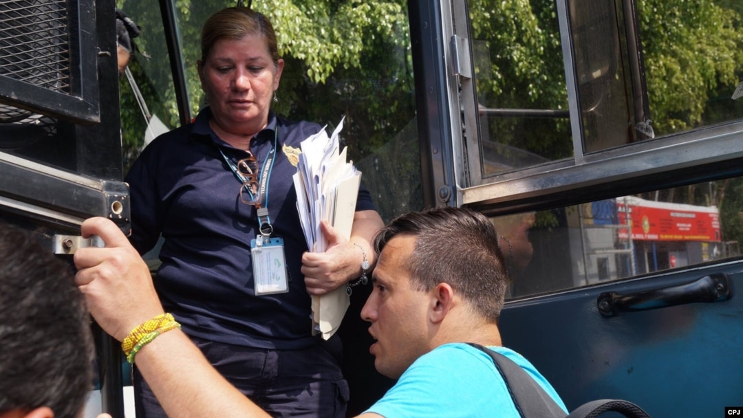 Agente de Migración de Costa Rica entrega visa a cubanos varados en ese país.