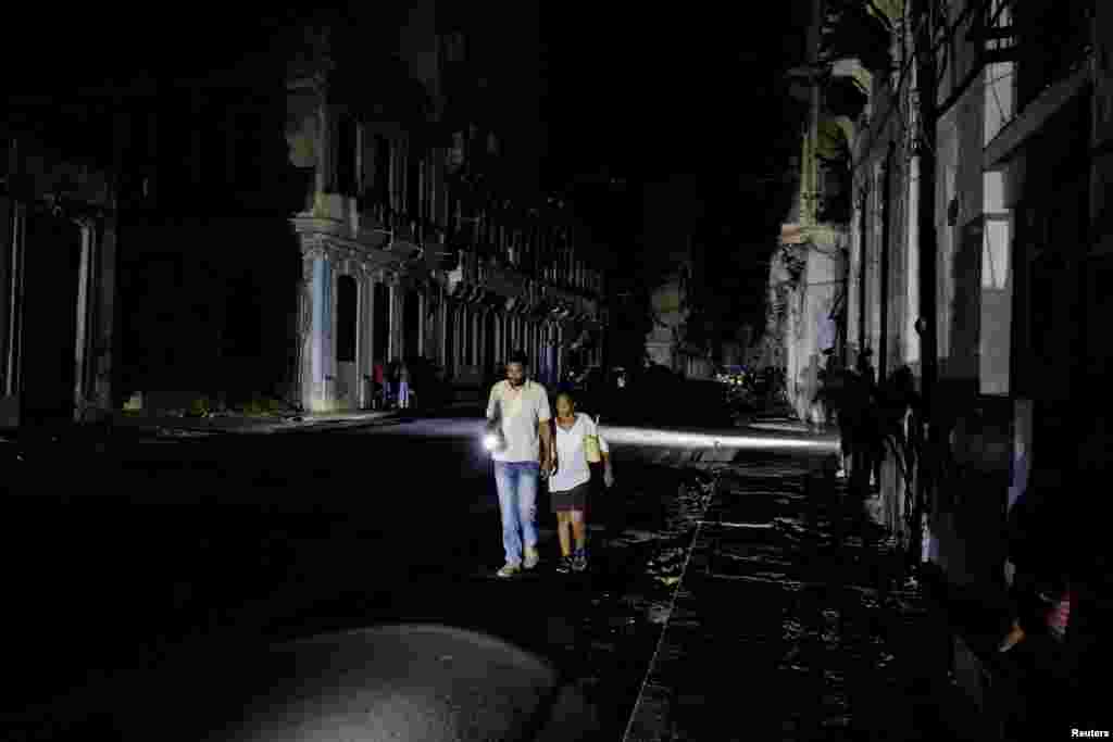 Personas caminan por una calle tras el colapso de la red eléctrica nacional de Cuba —el tercer apagón importante en nueve días— en La Habana, Cuba, el 14 de julio de 2026. REUTERS/Norlys Perez