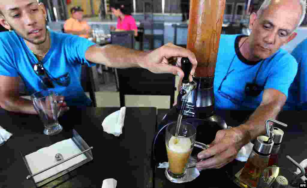  Dos hombres llenan una jarra de cerveza en el antiguo Muelle de la Madera y el Tabaco, en La Habana (Cuba). 