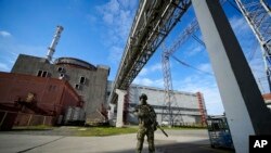 ARCHIVO - Un militar ruso vigila un área de la central nuclear de Zaporizhzhia, en el sureste de Ucrania, el 1 de mayo de 2022. La ONU adoptó una resolución donde exige a Rusia que retire urgentemente a su ejército y su personal de la central nuclear. (Foto AP/Archivo)