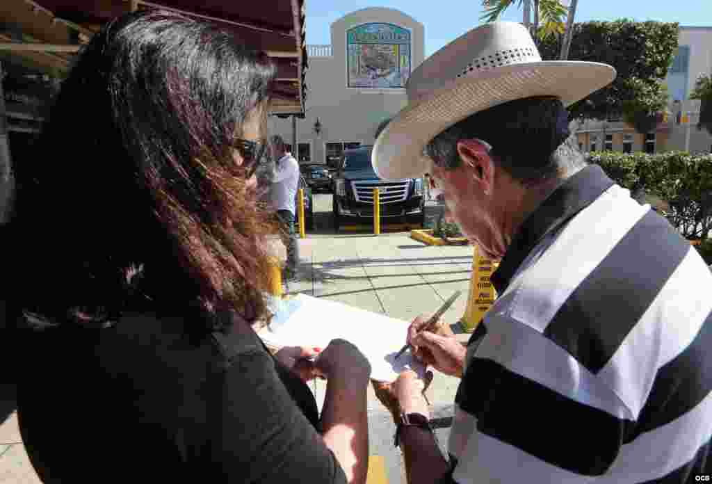A la izquierda, el exiliado cubano Nelson Valdés firma la petición. A su lado, María A. Lima, del Directorio Democrático Cubano. (Foto: Roberto Koltun)