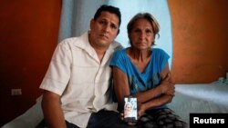 Alberto Betancourt y su madre Mayra Pérez posan con una foto de su hermana Daylin Betancourt, detenida por la policía el 11 de julio en La Habana. Fotografía tomada el 19 de julio de 2021. REUTERS / Alexandre Meneghini