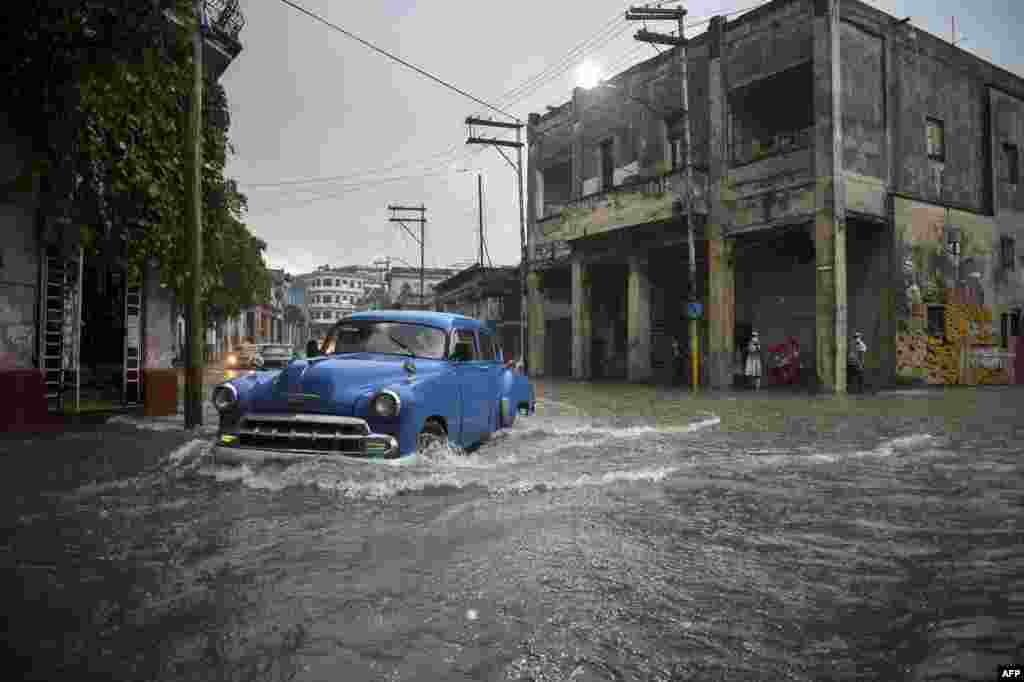 Un auto se aventura a trav&#233;s de una calle inundada en el municipio Diez de Octubre, en La Habana. (YAMIL LAGE / AFP)